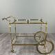 Rolling table cart in gilded brass with two glass shelves, 20th century.