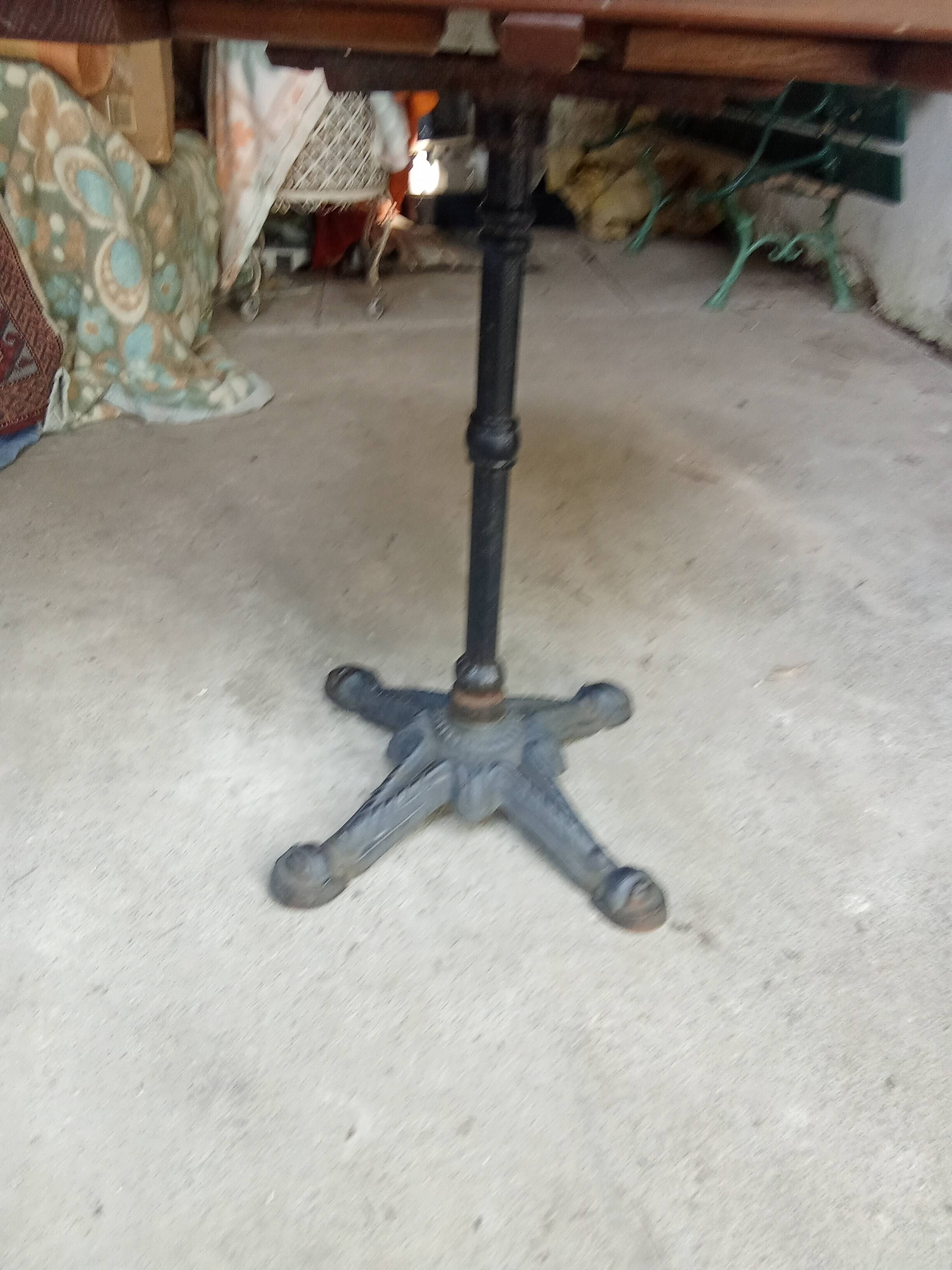 Bistro table with a cast iron base and a wooden top.