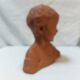 Terracotta bust of a smiling little boy.