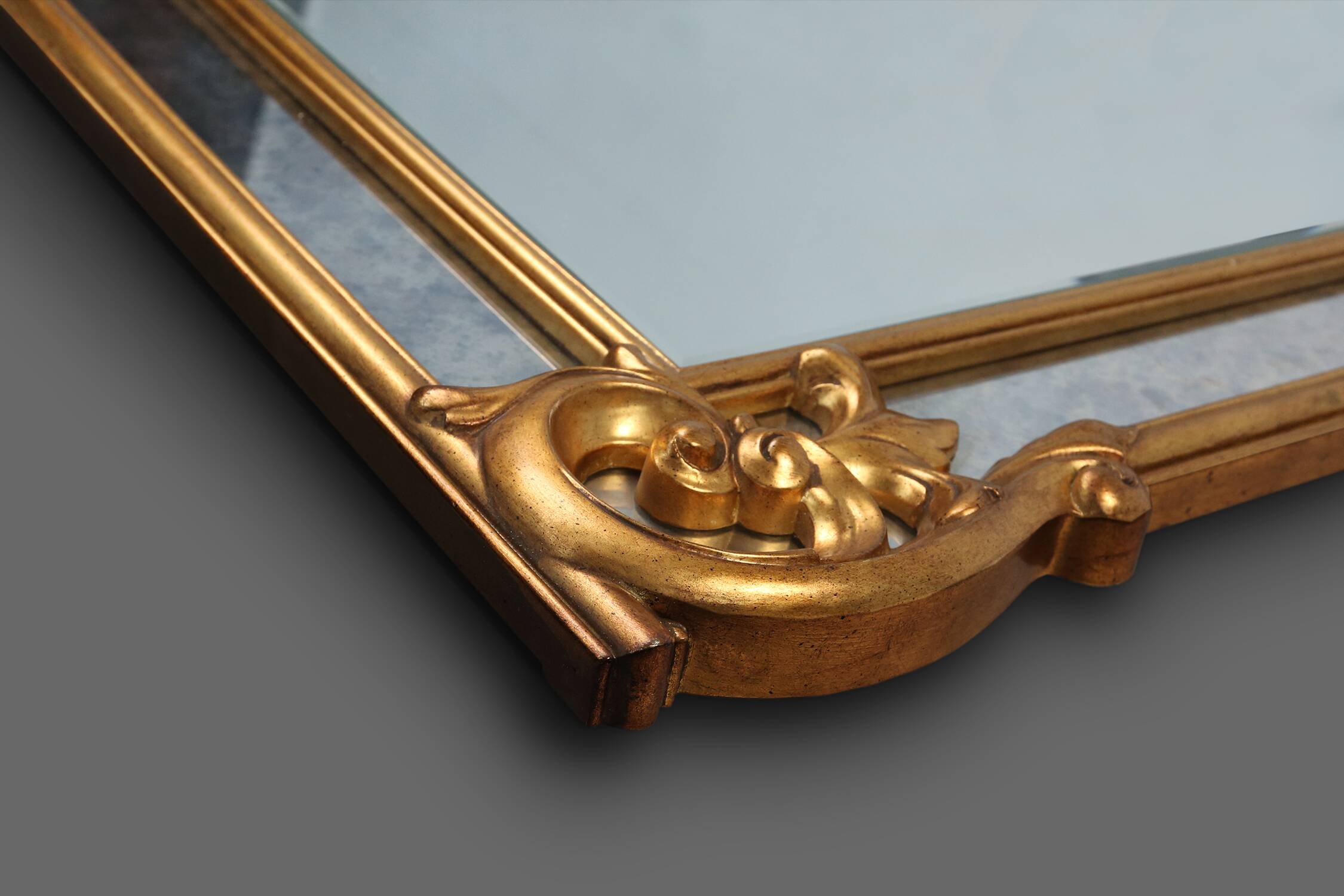 Richly decorated wall mirror in resin with golden ornaments and smoked mirror glass panels, Belgium,