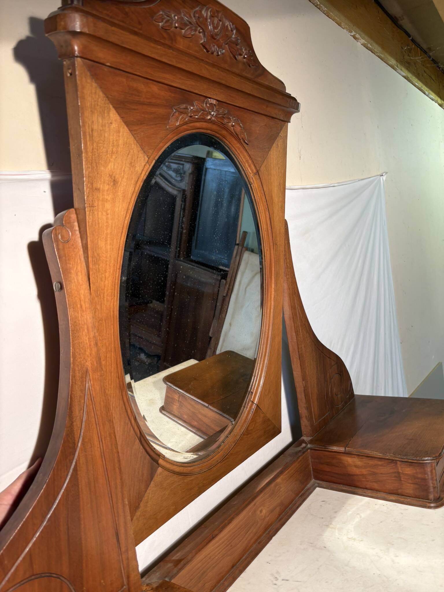 Antique carved wooden dressing table with marble and tilting oval mirror.