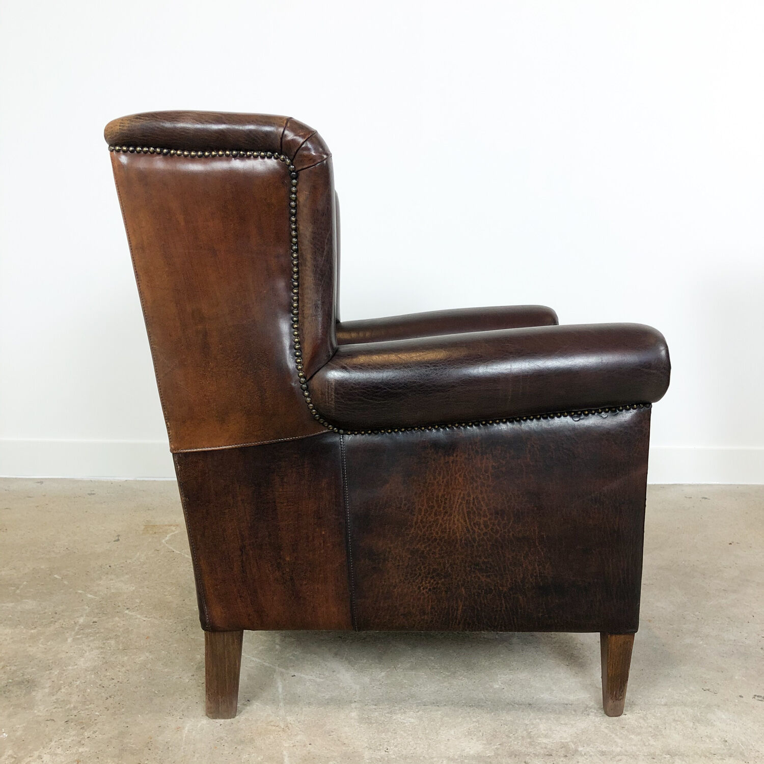 Paire de fauteuils à ailes en cuir de mouton brun foncé vintage