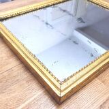 Old mercury mirror in carved wood, gilded with leaf.