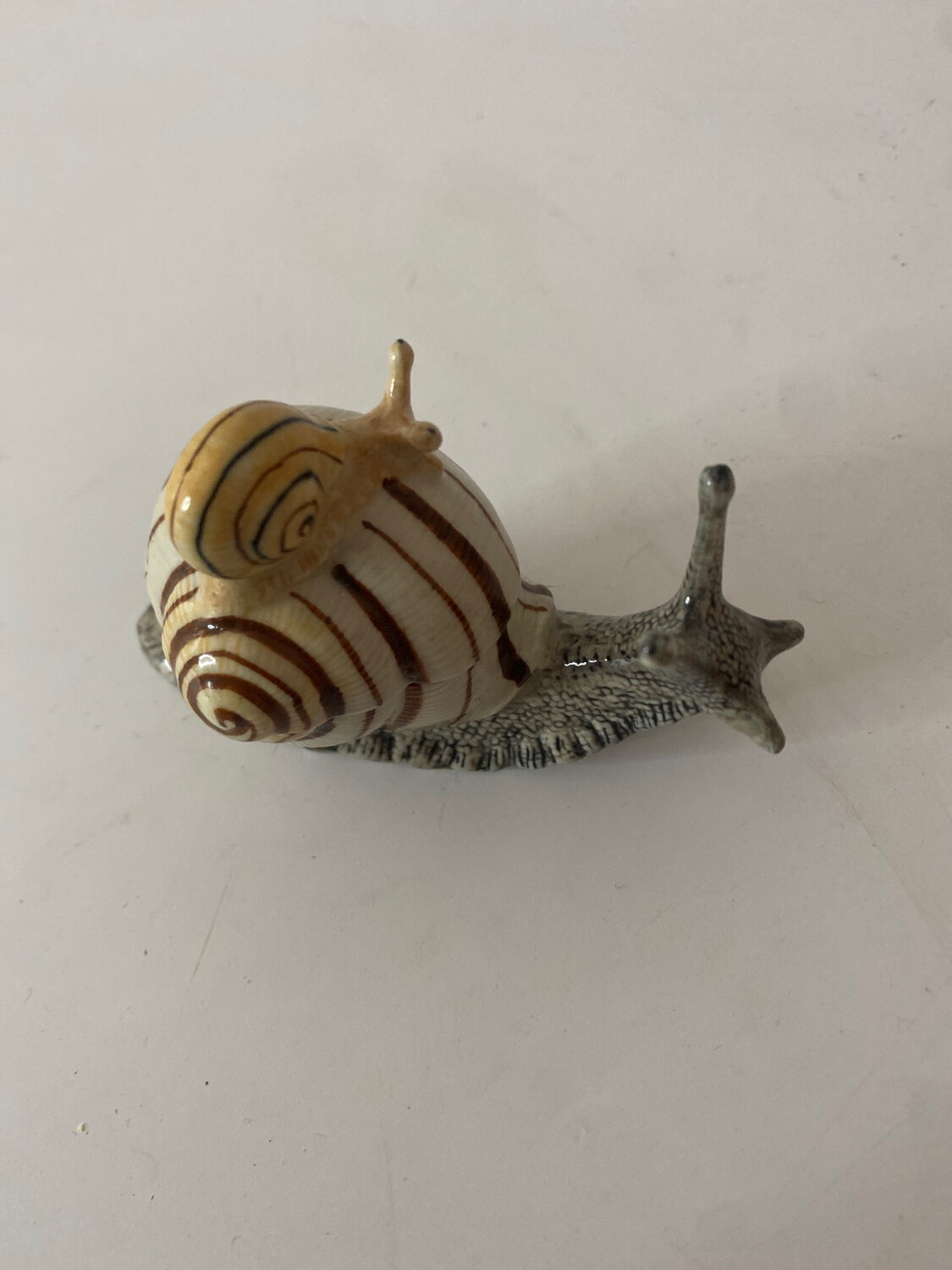 Porcelain figurine snail and its small