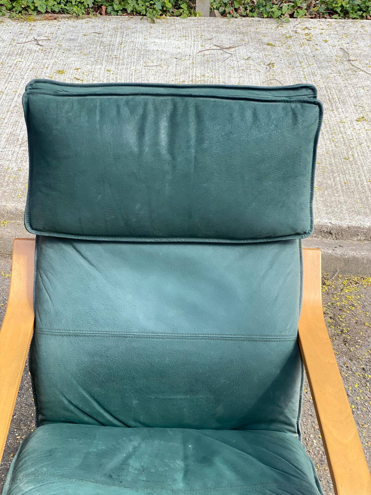 Scandinavian rocking chair with curved wood and green leather, IKEA Poäng.