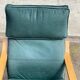 Scandinavian rocking chair with curved wood and green leather, IKEA Poäng.