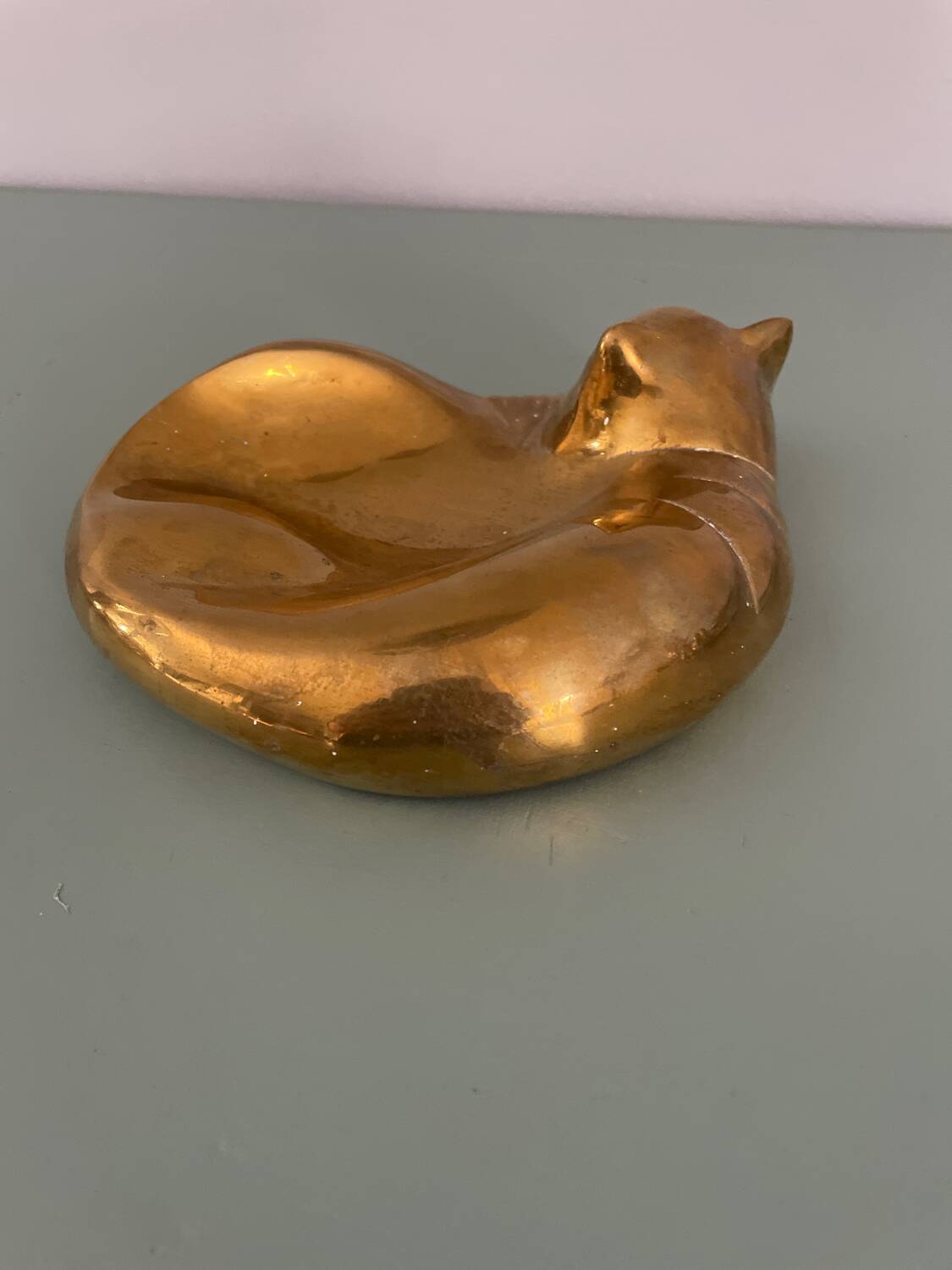Cat-shaped catchall that looks like it's sleeping.