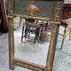 Empire-style mirror in deep green lacquered wood richly enhanced.