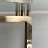 Console en acier brossé et laiton et plateau formé d'une dalle de verre. Travail français. Vers 1970