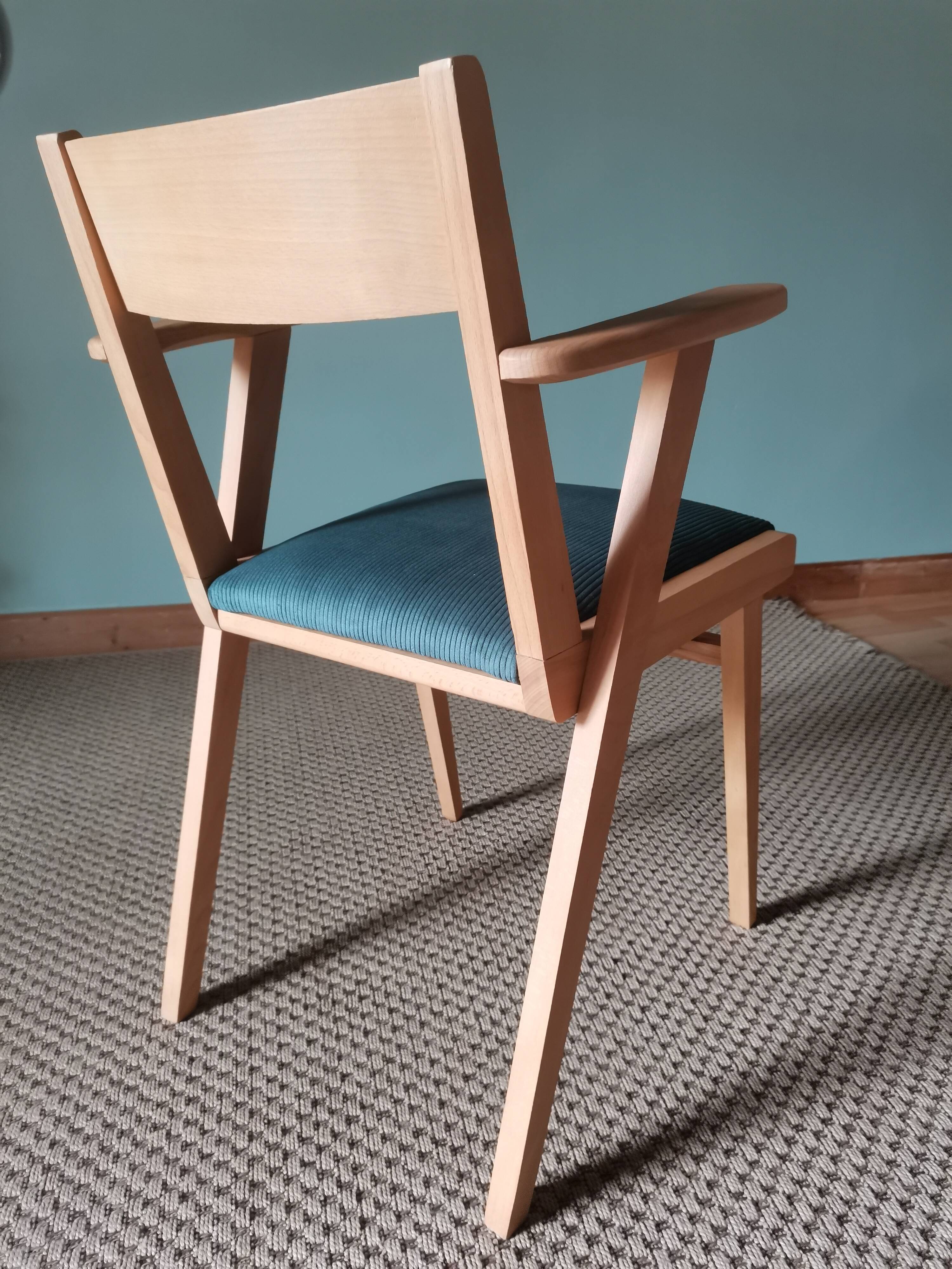 Scandinavian armchairs with green tapered legs.