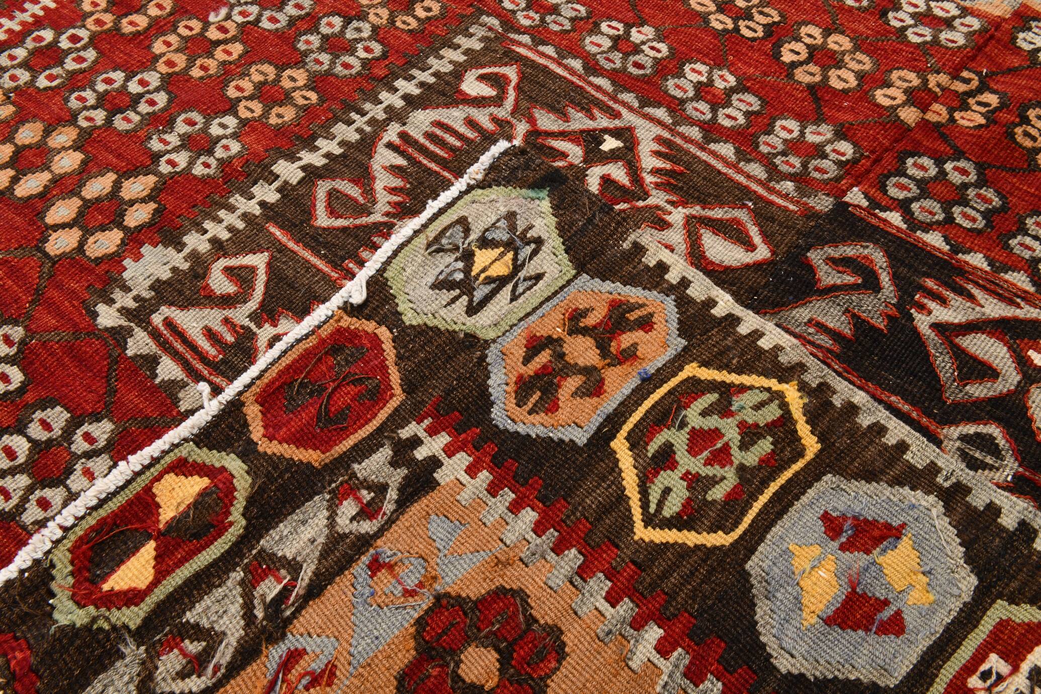 Kilim anatolien ancien tons rouges et beiges, motifs tribaux colorés