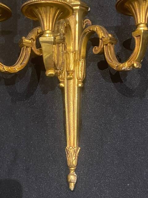 Pair of gilt bronze wall sconces with three lights in the Louis XVI style.