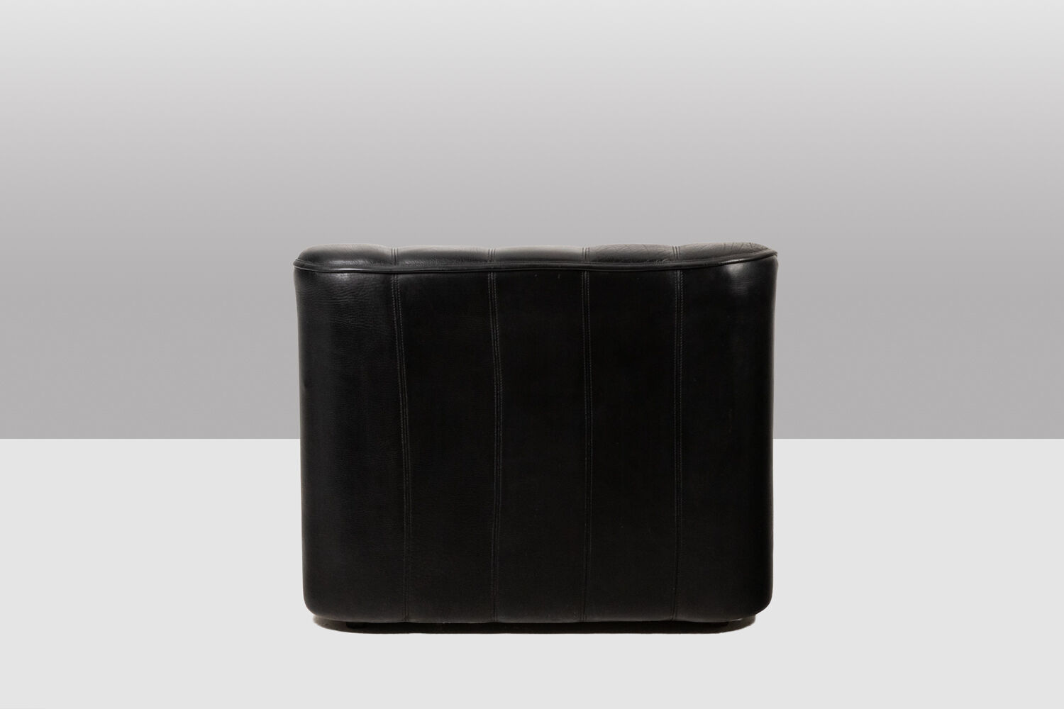 Maison De Sede. Armchair and its ottoman in black leather. 1970s.