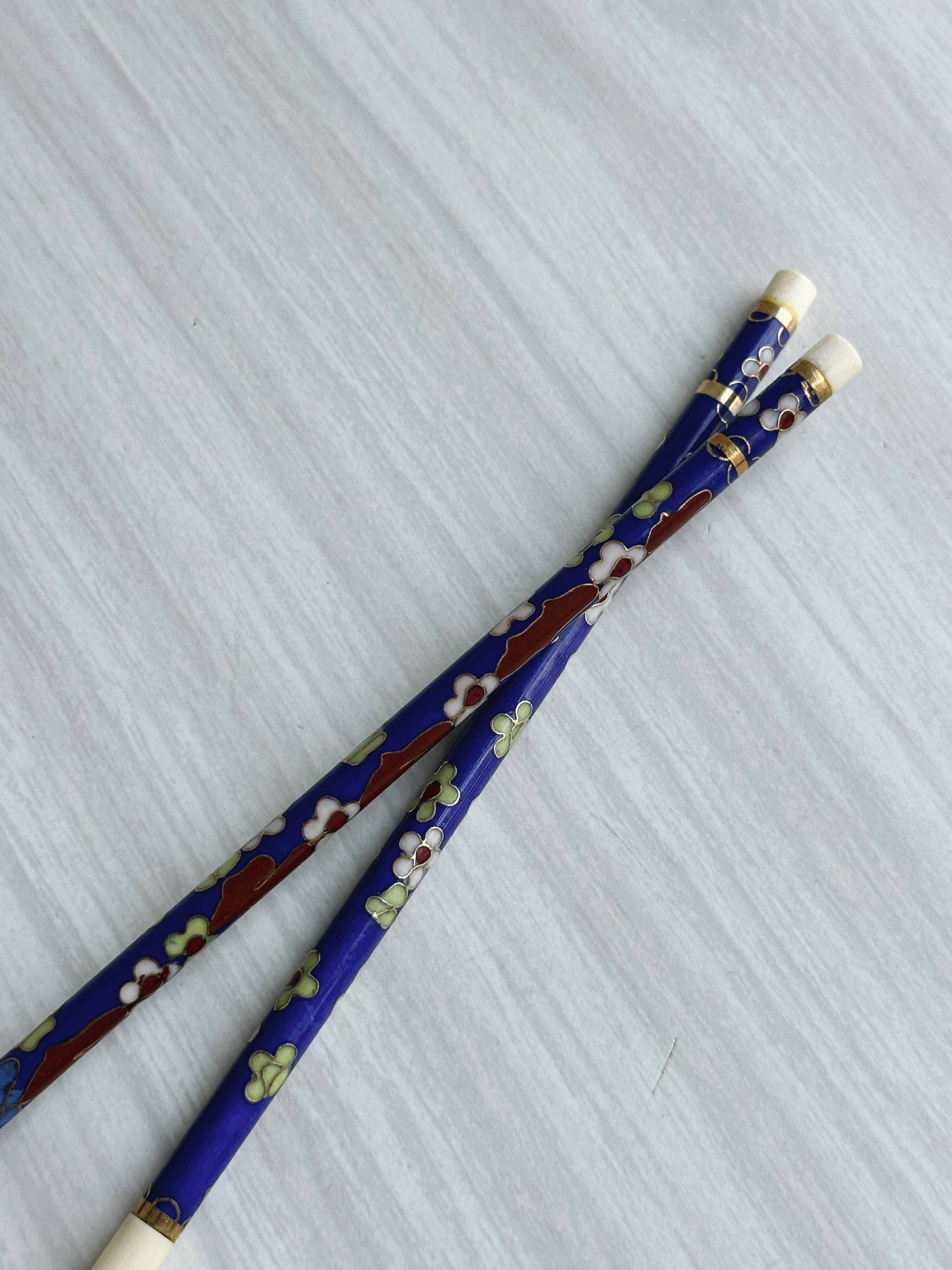 Blue chopsticks decorated with floral motifs.