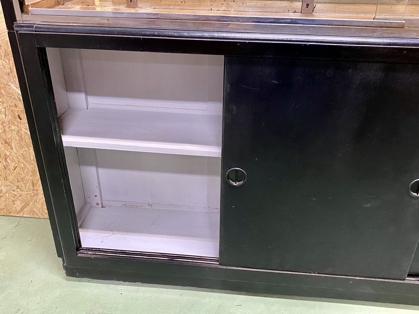 Store window with sliding doors in matte black patinated oak - 30s