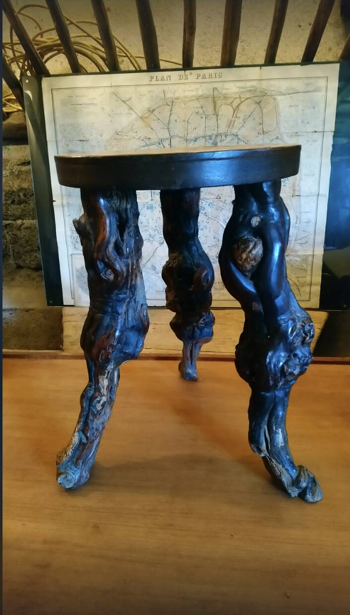Brutalist tripod stool made from vine stumps.