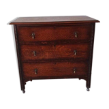 Antique oak chest of drawers on castors with brass handles and carved details