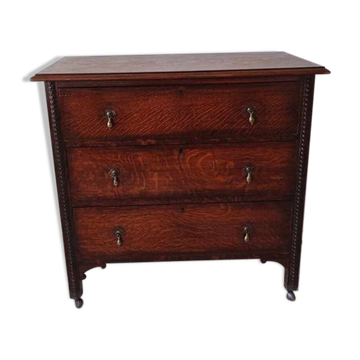 Commode ancienne sur roulettes en chêne sculpté et laiton