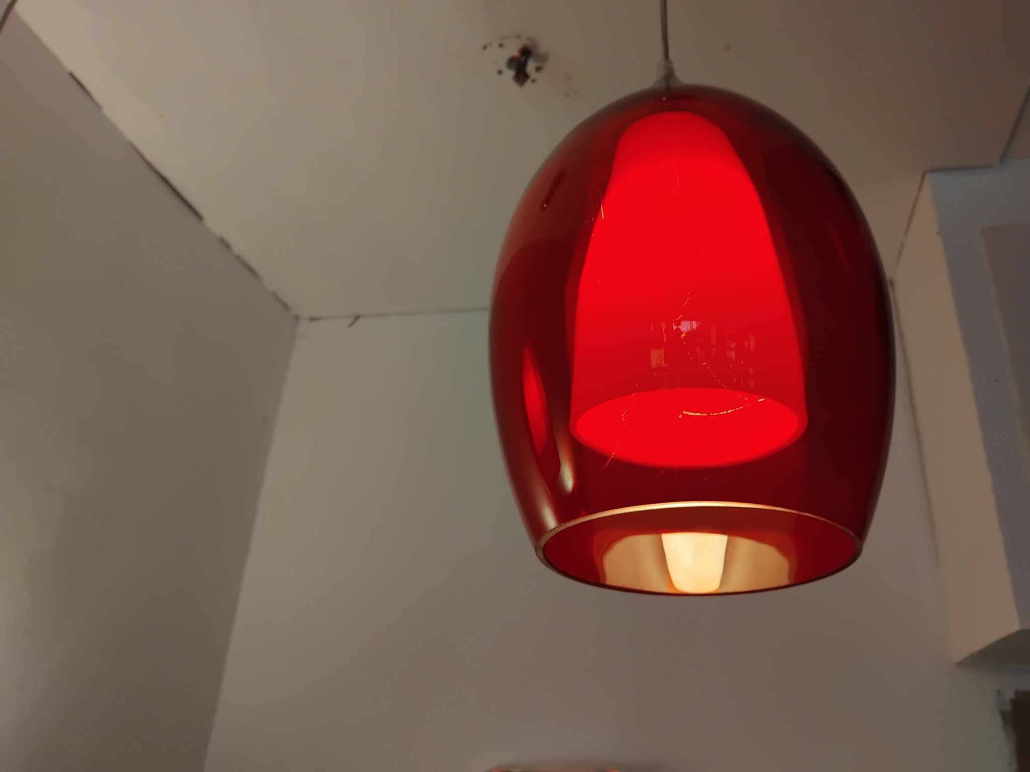 Pair of conical pendant lights in red tinted glass