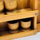 Wall-mounted egg cup holder and wooden utensil holder.