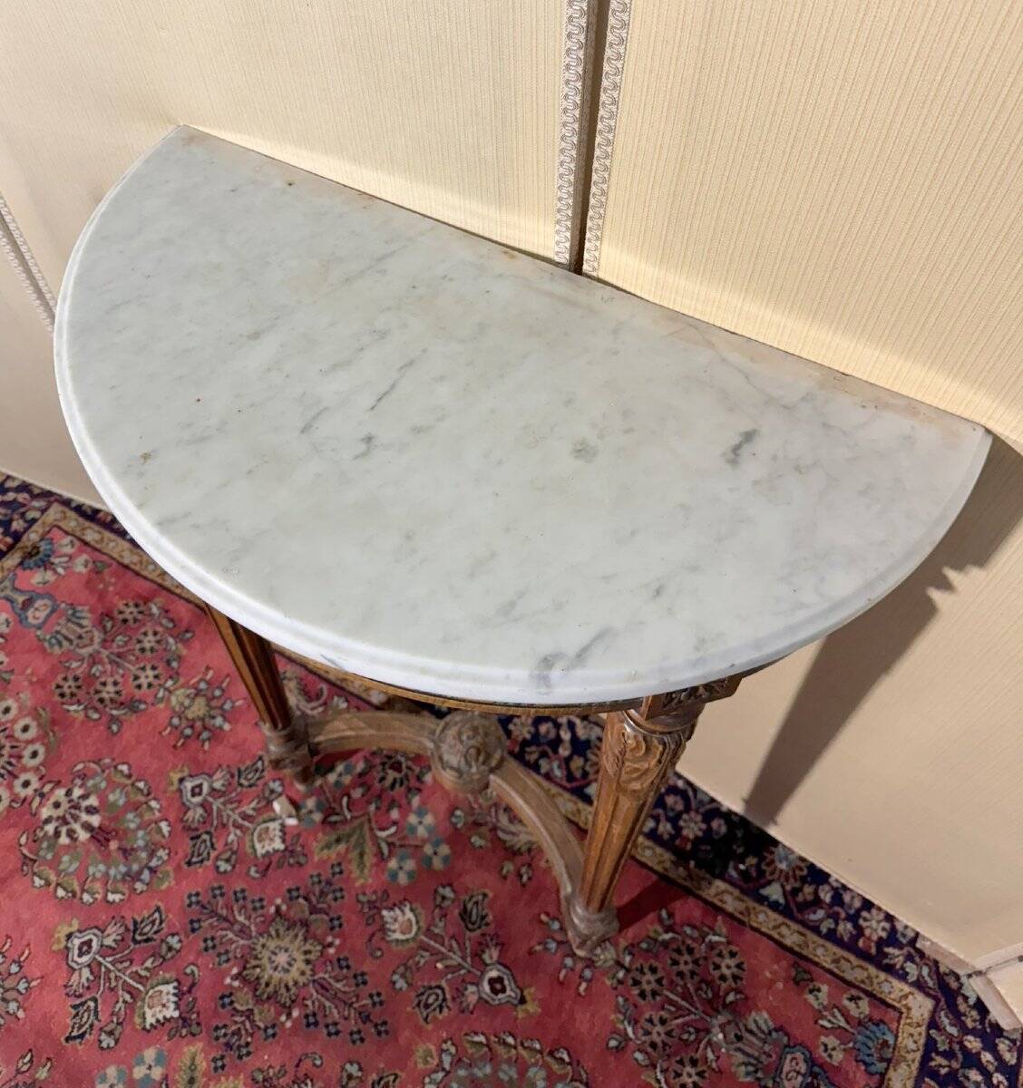 Half-moon console in Louis XVI style made of carved wood.