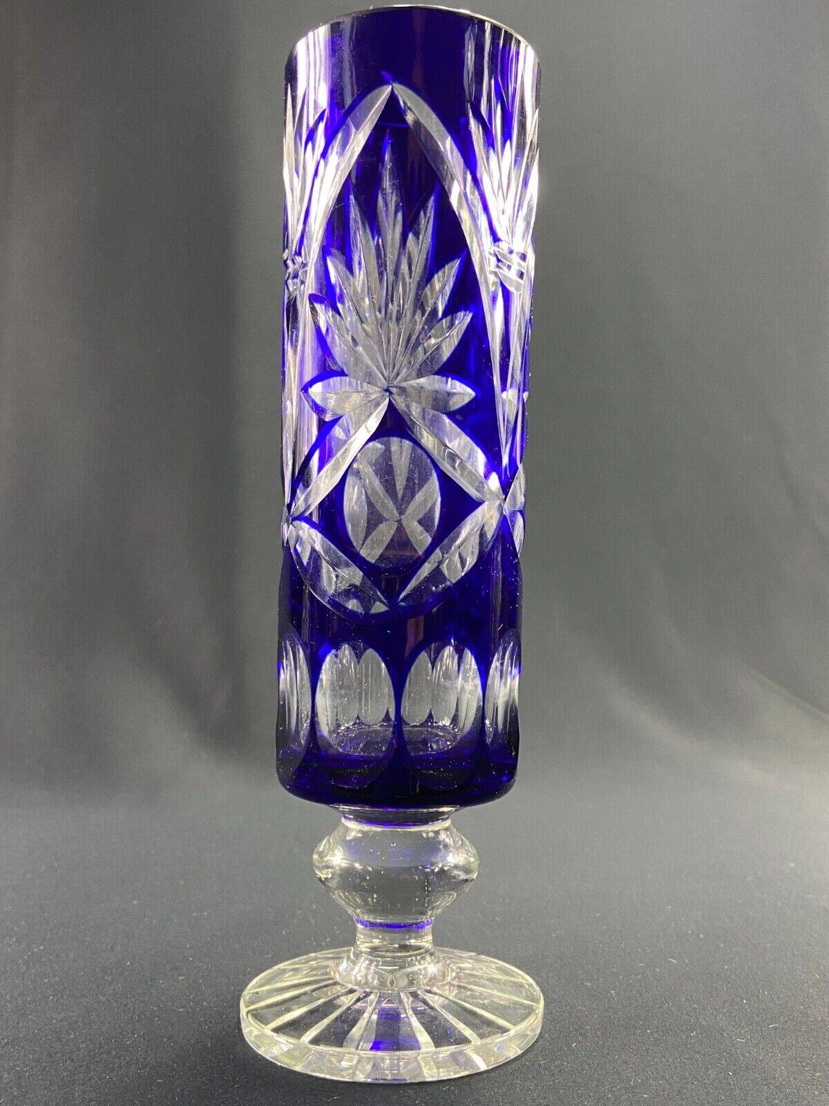 Tubular vase on a pedestal in cut blue Bohemian crystal.