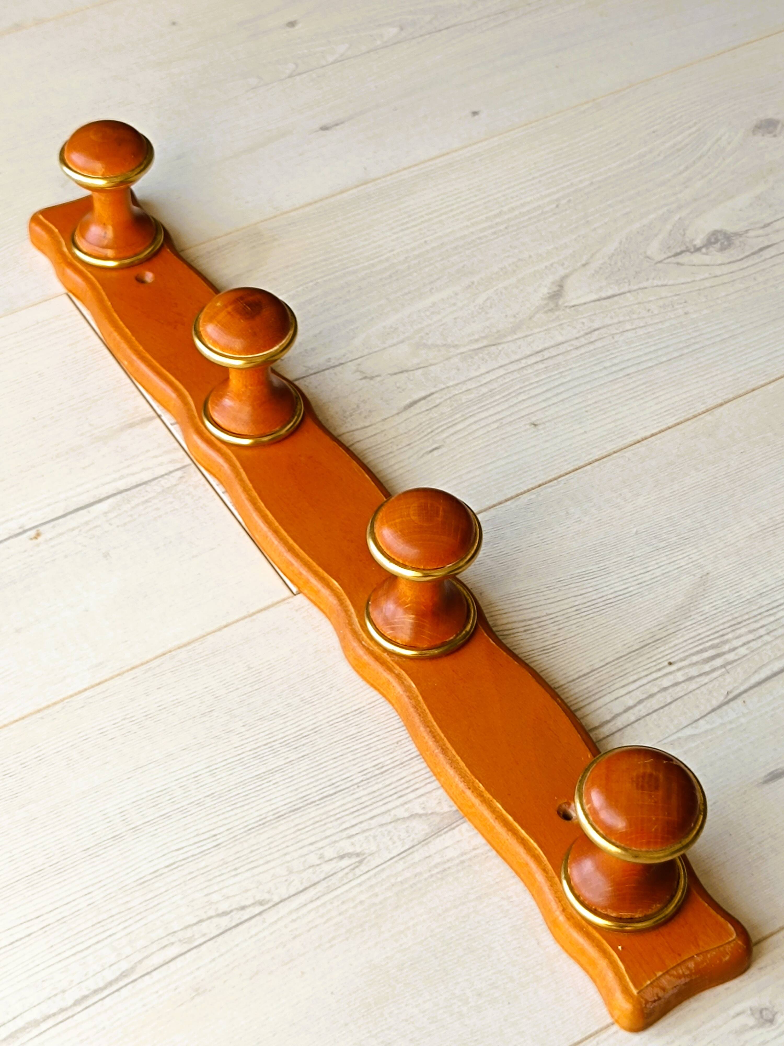 Wall-mounted coat rack in wood and brass