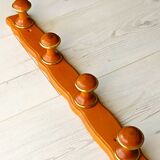 Wall-mounted coat rack in wood and brass