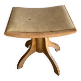 Vintage natural wood stool with light yellow faux leather seat and crossed splayed base