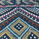 Blue carpet with multicolored patterns woven hands in natural wool