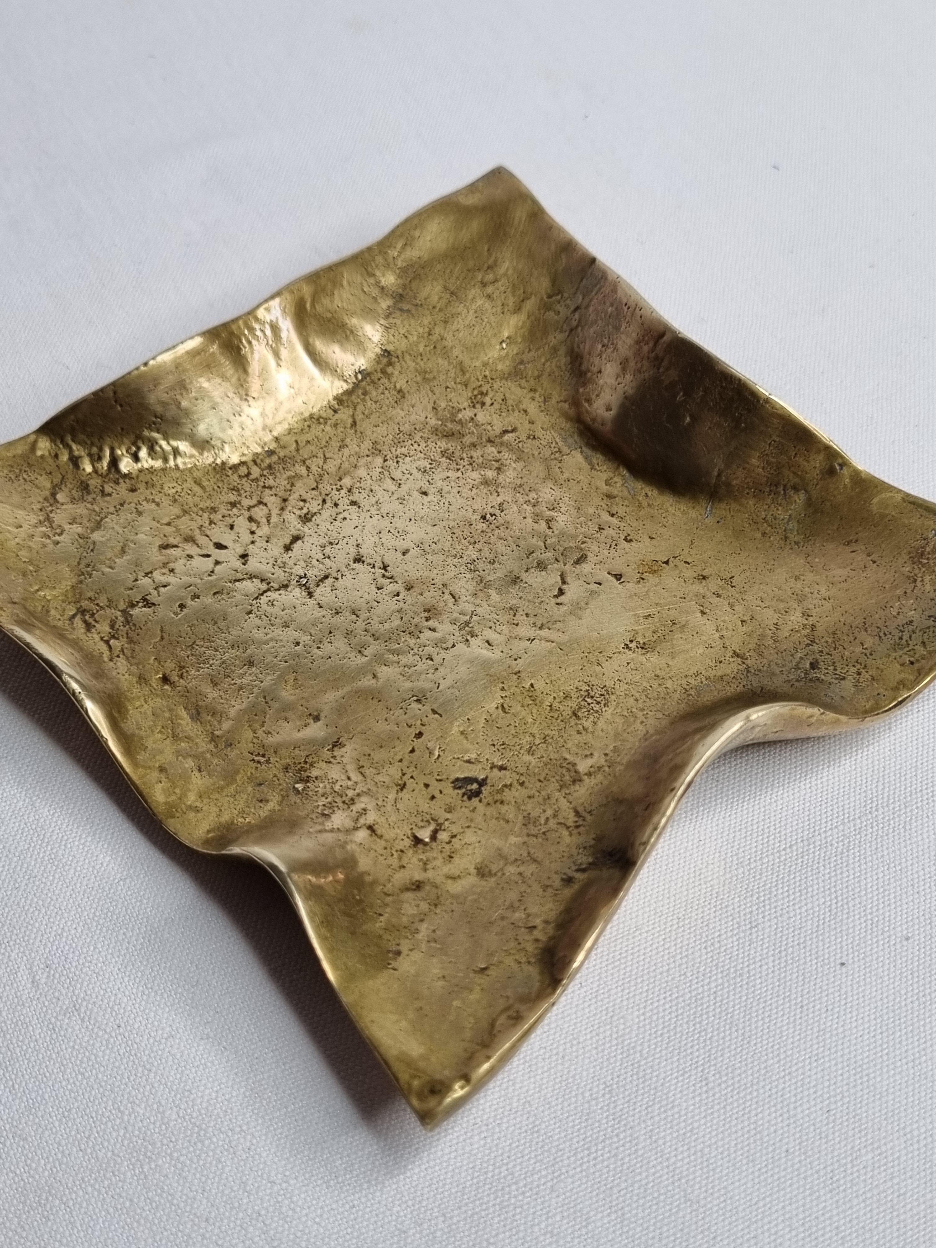 Empty pocket in polished brass representing a crumpled paper, signed CJ, 11.5 cm
