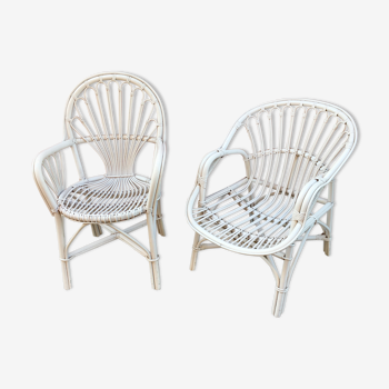 Two white rattan armchairs