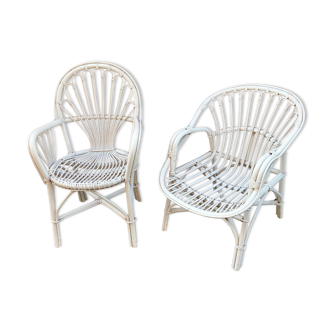Two white rattan armchairs