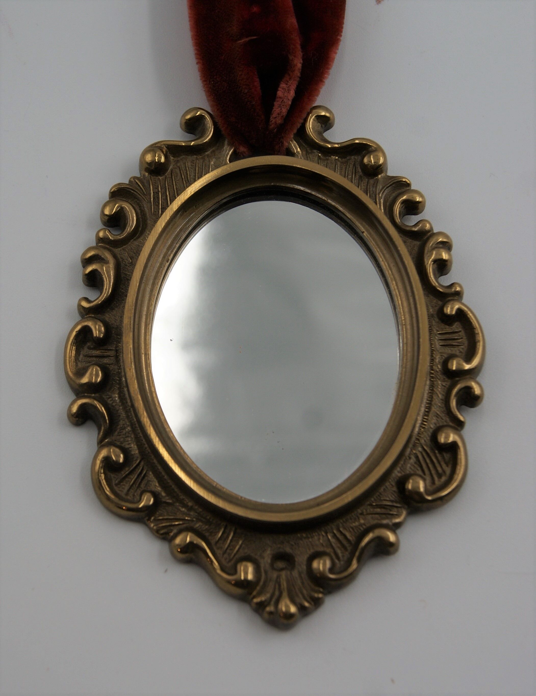 Vintage oval wall-mounted brass mirror