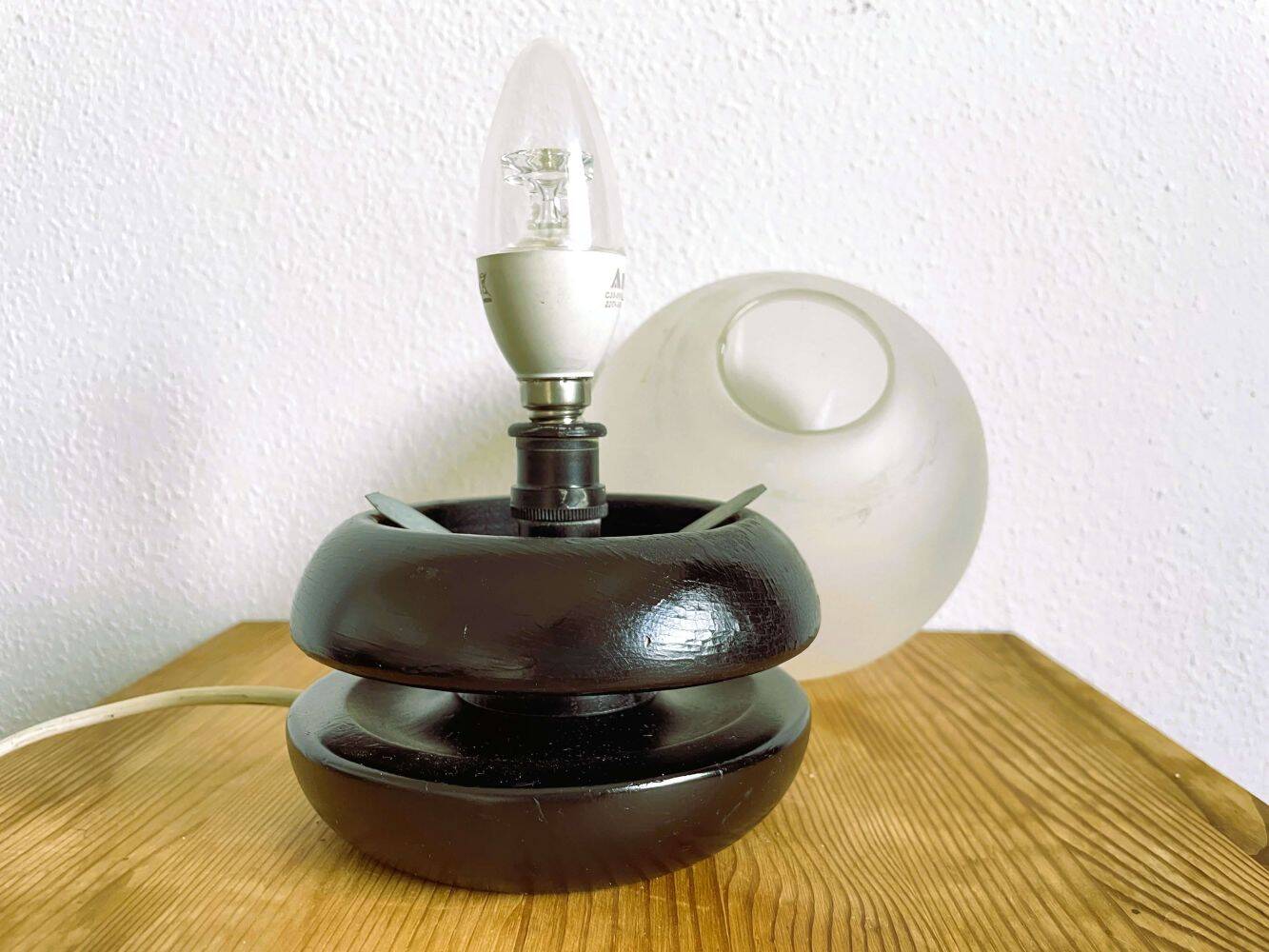 Small black wooden table lamp with frosted glass globe