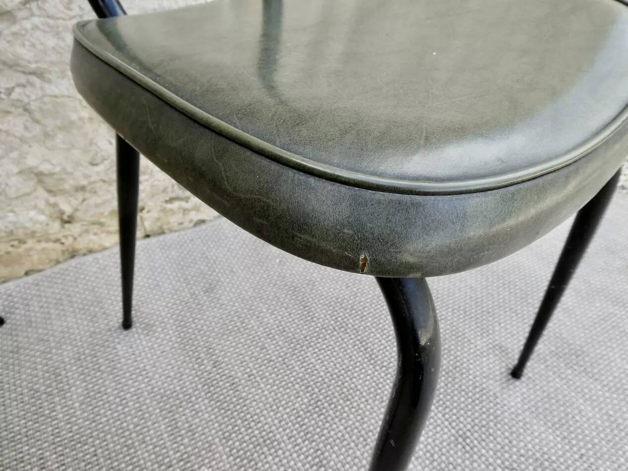 Black metal chairs with khaki faux leather seats, circa 1960.