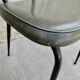 Black metal chairs with khaki faux leather seats, circa 1960.