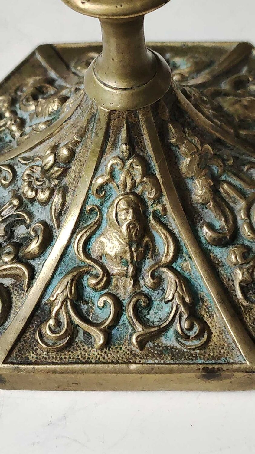 Baroque/Antique style torch candleholder, nineteenth, gilded bronze. Head motifs, volute arabesques