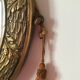 Golden oval mirror with its wooden frame and stucco on wood, nicely cracked by time