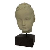 Plaster head of a young girl on a pedestal.