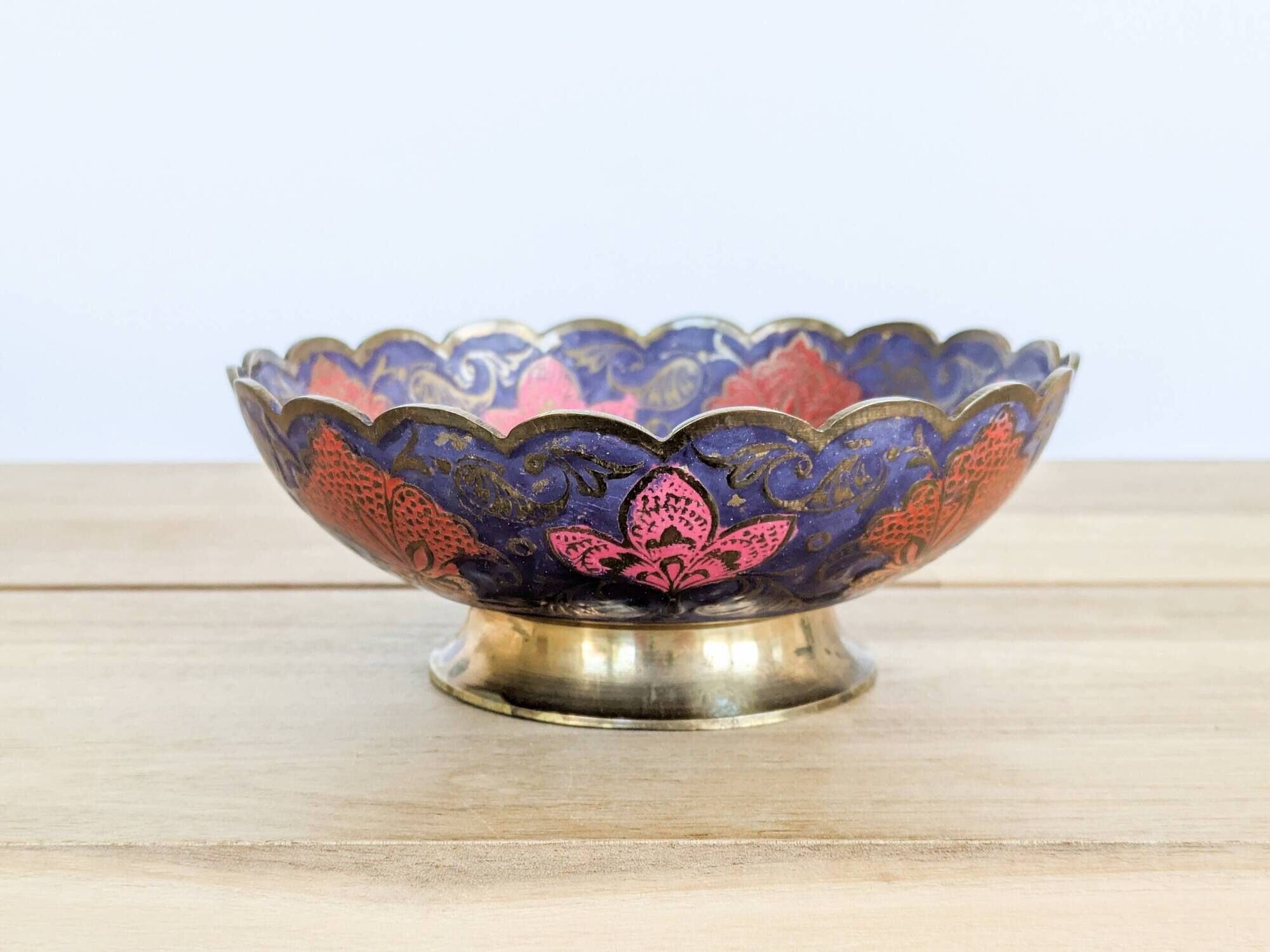 Vintage brass bowl with peacock motif, painted enamel, scalloped edge on a pedestal.
