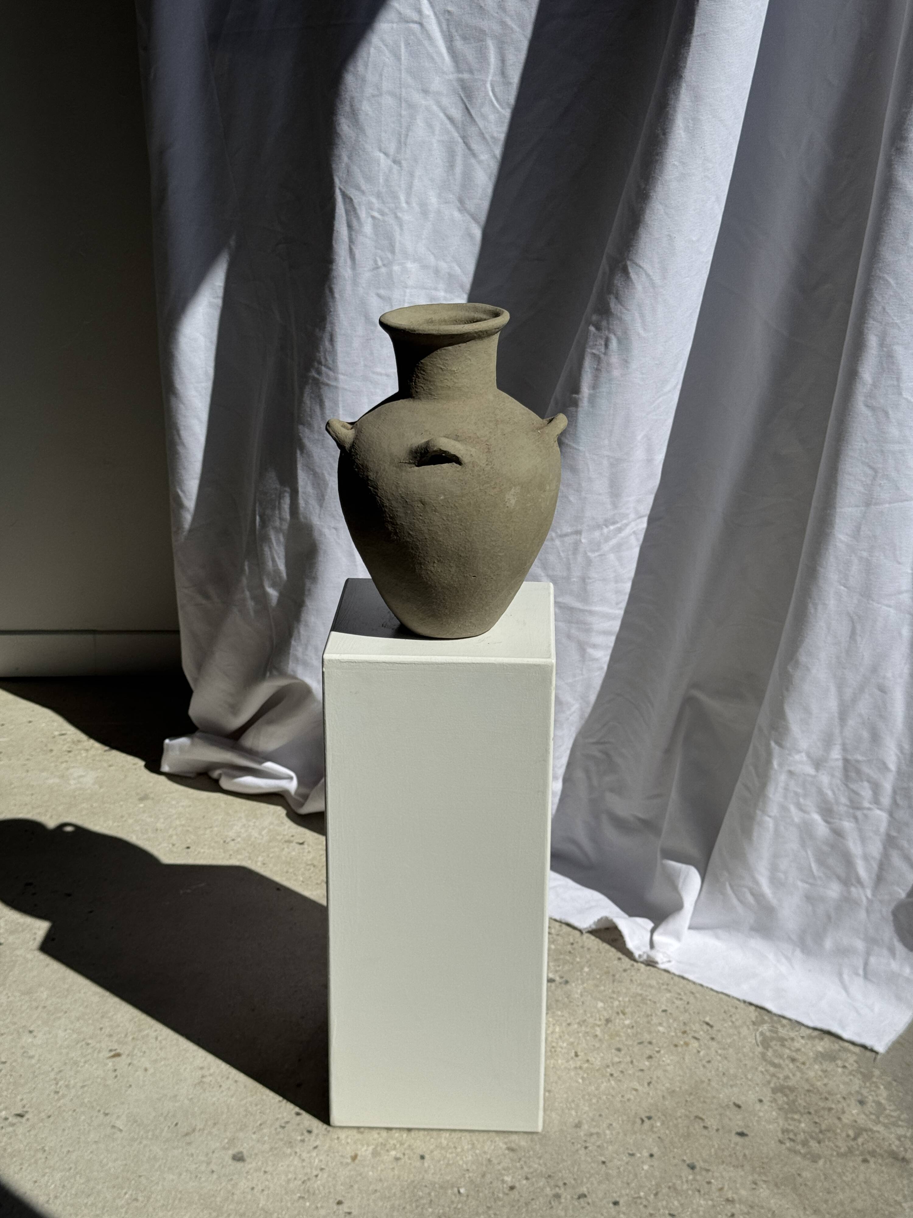 Light beige-grey Indonesian terracotta vase with 4 small handles and a high neck.