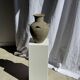 Light beige-grey Indonesian terracotta vase with 4 small handles and a high neck.