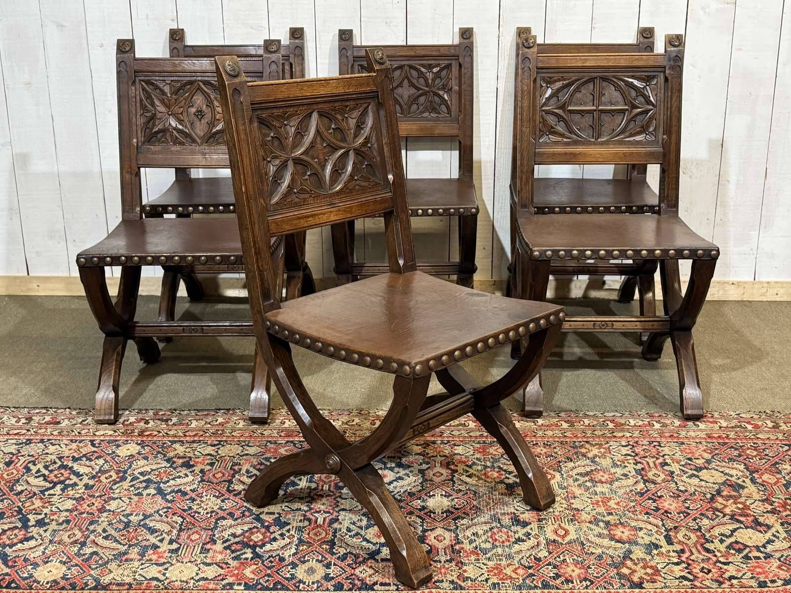 Suite de 6 chaises et 2 fauteuils en chêne et cuir à décor gothique
