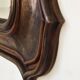 Italian sculpted mirror, patinated brown and gold wood, architectural frame from the 1960s.
