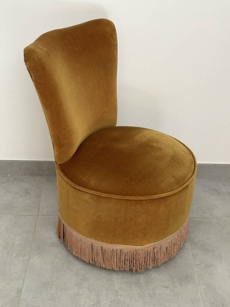 Ochre and fringed pouffe-style armchair