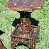 A folding chair and a carved Syrian table with 19th-century mother-of-pearl inlays.