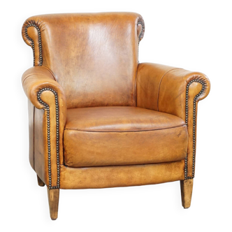 Comfortable, cozy armchair made of sheepskin leather with a proper finish with decorative nailheads