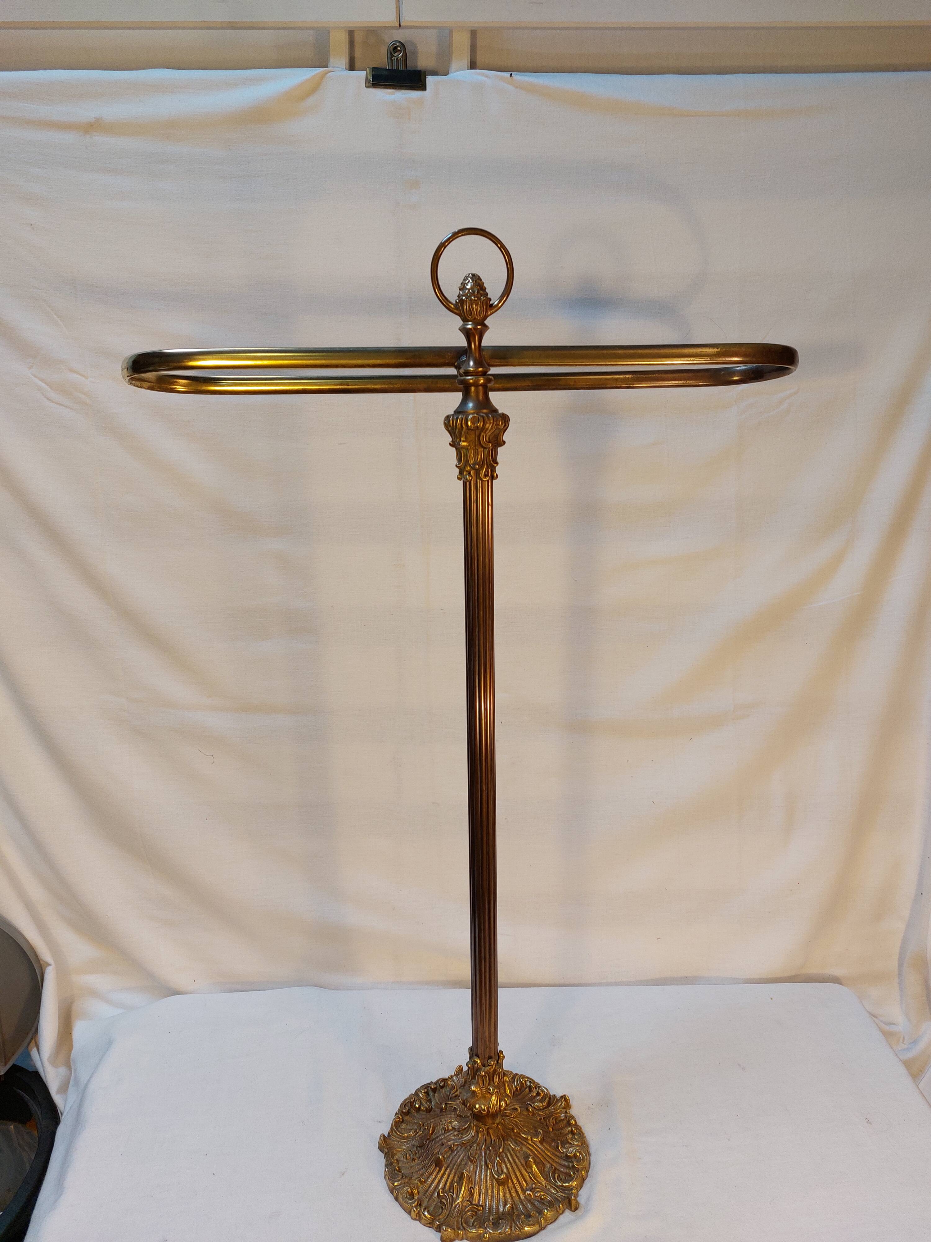 Old golden brass towel rack on baroque style foot