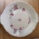 12 plates and 1 serving dish, white porcelain with apple blossom patterns.